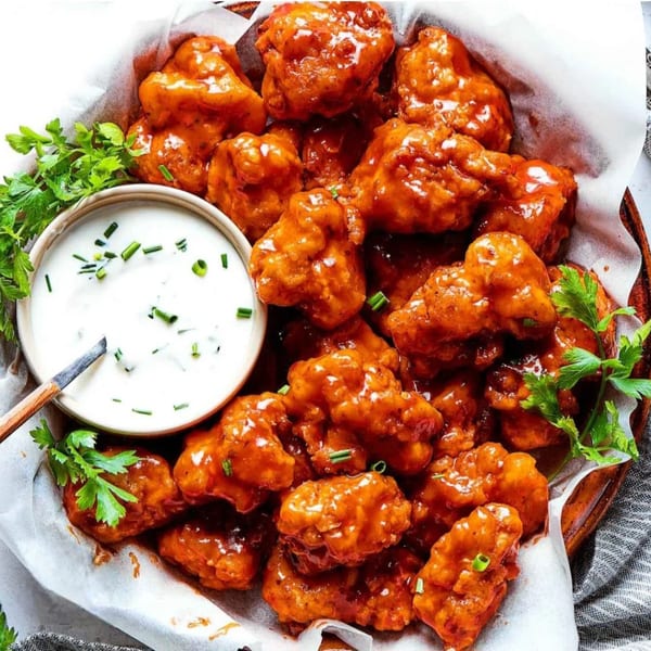 Ray's Chicken & Fish's orange-glazed boneless wings with a side of ranch dressing and parsley.